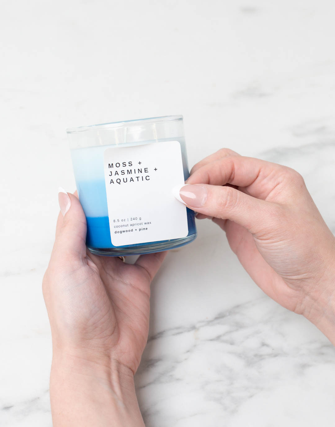 Adding a label to a completed ombre blue candle.